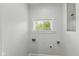 Laundry room featuring a bright window, white walls, and utility connections at 625 N Temple Ave, Indianapolis, IN 46201
