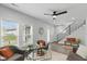 Cozy living area with staircase, large windows, and comfortable seating with bright orange accents at 625 N Temple Ave, Indianapolis, IN 46201