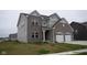 Well-maintained two-story home with a brick and siding exterior, spacious lawn, and attached two-car garage at 6304 Frst Brk Dr, Indianapolis, IN 46259