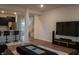Open-concept living space featuring a kitchen island, hardwood floors, and large TV with a console at 6304 Frst Brk Dr, Indianapolis, IN 46259