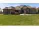 Brick home exterior featuring a spacious backyard with a deck and patio seating area for outdoor enjoyment at 6472 Independence Ct, Pendleton, IN 46064