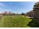 Brick home exterior with a large backyard featuring a deck and patio seating area surrounded by lush greenery at 6472 Independence Ct, Pendleton, IN 46064