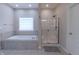 Bright bathroom features a stand-up shower with glass doors and a soaking tub under a window at 6472 Independence Ct, Pendleton, IN 46064