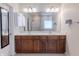 Modern bathroom featuring double sinks, large mirror, neutral colors, and access to walk-in closet at 6472 Independence Ct, Pendleton, IN 46064