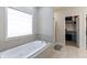 Bathroom featuring a large soaking tub, walk-in closet, and neutral tile work at 6472 Independence Ct, Pendleton, IN 46064
