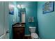 Stylish half-bathroom with granite countertop, turtle artwork, and vibrant turquoise walls at 6472 Independence Ct, Pendleton, IN 46064