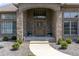 Inviting covered front entryway, brick surround, beautiful wooden door with decorative wreath and manicured shrubs at 6472 Independence Ct, Pendleton, IN 46064
