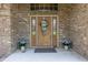 Inviting brick home entrance features a decorative floral wreath and charming blue hydrangeas at 6472 Independence Ct, Pendleton, IN 46064
