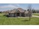 Beautiful single-story brick home with lush green lawn, a mature tree, and a welcoming covered entryway at 6472 Independence Ct, Pendleton, IN 46064