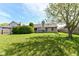 A fully fenced in backyard with a deck, mature tree and plenty of green space at 7332 Quartz Rock Rd, Indianapolis, IN 46236