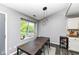 Modern dining area with sleek table, pendant lights, and view to the outside at 7332 Quartz Rock Rd, Indianapolis, IN 46236