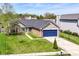 Charming brick home with a well-manicured lawn and a blue two-car garage at 7332 Quartz Rock Rd, Indianapolis, IN 46236