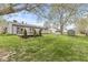 Spacious backyard featuring a deck, mature trees, lush lawn, storage shed and a fire pit area at 7656 Madden Ln, Fishers, IN 46038