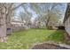 Large fenced backyard with a fire pit, mature trees, and a view of neighboring houses at 7656 Madden Ln, Fishers, IN 46038