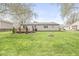 Expansive lawn with a cozy fire pit, wooden deck, and mature landscaping in the backyard at 7656 Madden Ln, Fishers, IN 46038