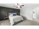 Bedroom with a dark accent wall, ceiling fan, and comfortable carpet at 7656 Madden Ln, Fishers, IN 46038