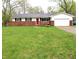 Charming ranch-style home featuring a brick facade, attached garage, and a red front door at 8017 Chiltern Dr, Indianapolis, IN 46268
