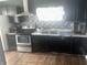 The kitchen features a stainless steel stove, black cabinets, and laminate countertop at 818 W 27Th St, Indianapolis, IN 46208