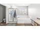 Clean bathroom featuring tub with tiled surround and glass shower stall at 8327 Andrusia Ln, Indianapolis, IN 46237