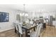 Bright dining area with an elegant light fixture and views of the modern kitchen and backyard at 8327 Andrusia Ln, Indianapolis, IN 46237