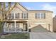 Inviting two-story brick home featuring a charming front porch and an attached two-car garage at 8327 Andrusia Ln, Indianapolis, IN 46237