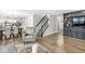 Open-concept living area with wood floors, a staircase, and a view of the dining and kitchen spaces at 8327 Andrusia Ln, Indianapolis, IN 46237