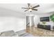 Open living room with wood floors, ceiling fan, and modern entertainment center at 8327 Andrusia Ln, Indianapolis, IN 46237