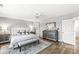 A serene main bedroom featuring a tufted headboard, mirrored nightstands and hardwood floors at 8327 Andrusia Ln, Indianapolis, IN 46237