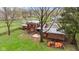 Aerial view of a backyard with a patio, a wood pile, and mature trees at 874 S Sycamore Dr, Greenfield, IN 46140