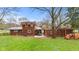 A backyard view with a patio and a wood pile. A car is parked nearby at 874 S Sycamore Dr, Greenfield, IN 46140