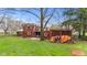 A backyard view featuring a patio and a wood pile, with mature trees at 874 S Sycamore Dr, Greenfield, IN 46140