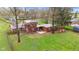 Aerial view of a backyard with a patio, wood pile and mature trees at 874 S Sycamore Dr, Greenfield, IN 46140