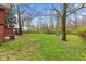 Expansive backyard featuring a grassy lawn, mature trees, and wood storage for serene outdoor enjoyment at 874 S Sycamore Dr, Greenfield, IN 46140