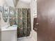 A compact bathroom with a white vanity, patterned shower curtain, mirrored cabinet, and neutral wall paint at 874 S Sycamore Dr, Greenfield, IN 46140