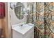 A compact bathroom featuring a white vanity and patterned shower curtain, complemented by an oval mirror at 874 S Sycamore Dr, Greenfield, IN 46140
