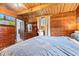 A cozy bedroom exhibits wood paneled walls, a window, and a chest of drawers, creating a warm and inviting space at 874 S Sycamore Dr, Greenfield, IN 46140
