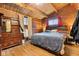 Rustic bedroom featuring wood walls, ceiling beams, and a comfortable bed with natural light from the windows at 874 S Sycamore Dr, Greenfield, IN 46140