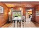 Dining room featuring wood walls, a dining table with seating for six, and kitchen views at 874 S Sycamore Dr, Greenfield, IN 46140