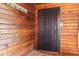 Cozy entryway featuring natural wood walls, a striking black door, and rustic coat hooks for a charming welcome at 874 S Sycamore Dr, Greenfield, IN 46140