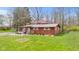 Charming single-story home boasts a lovely yard and a cozy front porch with American flags at 874 S Sycamore Dr, Greenfield, IN 46140