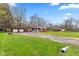 Beautifully landscaped lawn with a charming single-story home featuring a detached two-car garage on a sunny day at 874 S Sycamore Dr, Greenfield, IN 46140