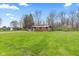 A well-maintained lawn surrounds a charming single-story home with a detached two-car garage and mature trees at 874 S Sycamore Dr, Greenfield, IN 46140