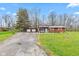 Charming single-story home with a cozy front porch, American flags, and a detached two-car garage at 874 S Sycamore Dr, Greenfield, IN 46140
