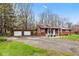 Charming single-story home with a cozy front porch, American flag, and a detached two-car garage at 874 S Sycamore Dr, Greenfield, IN 46140