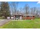 Quaint single-story home featuring a cozy front porch with the American flag and a detached two-car garage at 874 S Sycamore Dr, Greenfield, IN 46140