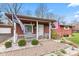 Cozy front porch with a white wicker chair, American flag, and well-maintained landscaping at 874 S Sycamore Dr, Greenfield, IN 46140
