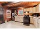 Rustic kitchen features wood paneled walls and ceiling, white cabinets, modern appliances, and plenty of natural light at 874 S Sycamore Dr, Greenfield, IN 46140