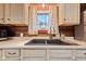 Rustic kitchen boasts white countertops and cabinets, dark sink basin, and natural light from the window at 874 S Sycamore Dr, Greenfield, IN 46140