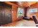 Cozy living room with natural wood walls, a black door, and bright windows for a warm, inviting space at 874 S Sycamore Dr, Greenfield, IN 46140