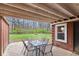 Covered patio with table and chairs overlooking the large backyard with a fire pit perfect for outdoor gatherings at 874 S Sycamore Dr, Greenfield, IN 46140